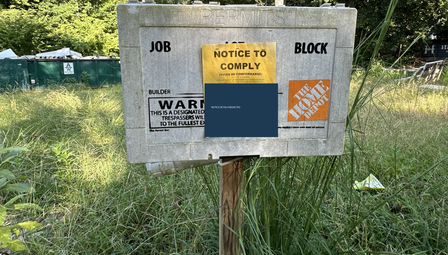 Notice to comply posted on a permit box, with identifying details redacted