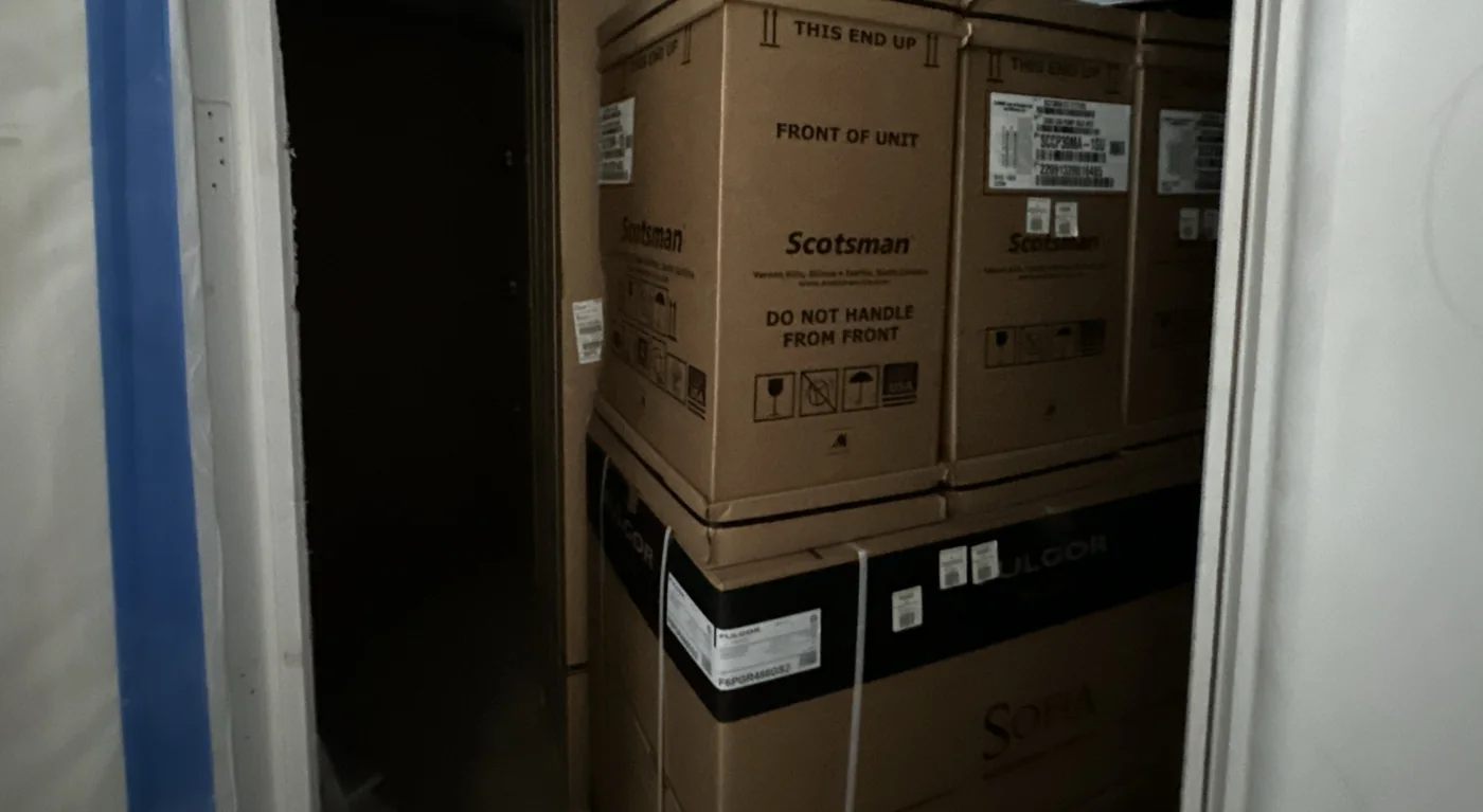 Large boxed appliances stored in a crowded space