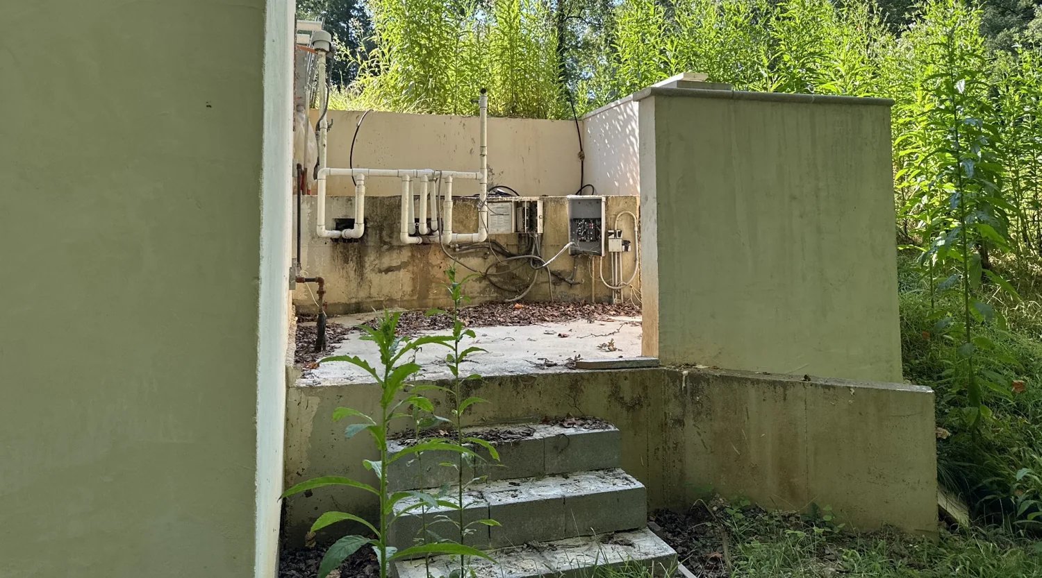 Pool equipment area with exposed plumbing and empty equipment space
