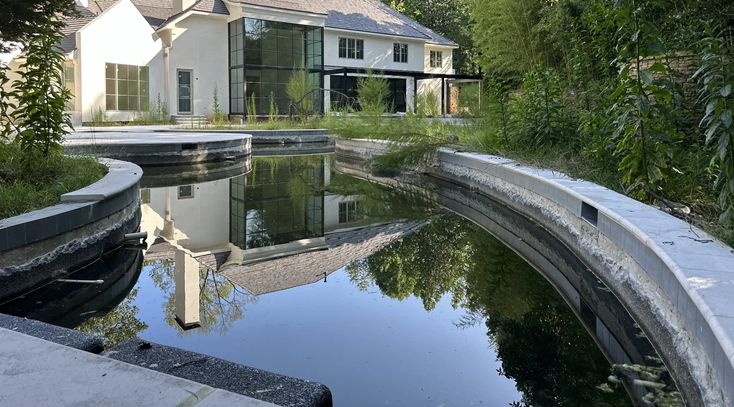 Rear of the home reflected in dark pool water