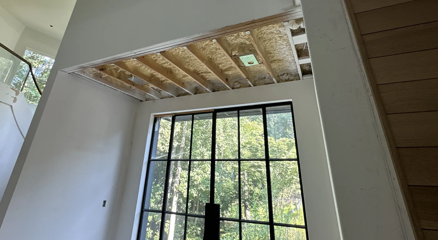 An open section of ceiling exposes framing